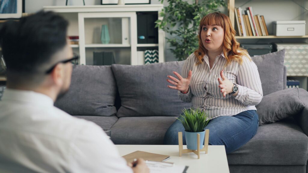 A therapy session in progress with a therapist and a patient discussing indoors.